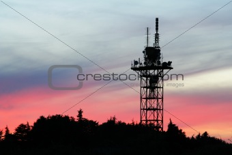 communication tower silhouette on sunset sky