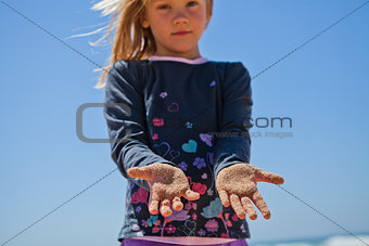 Young girl with sand covered hands