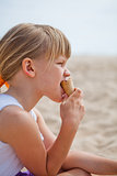 Young girl eating ice cream on beach