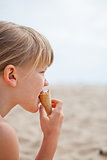 Young girl eating ice cream on beach
