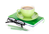Green coffee cup, glasses and office supplies