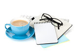 Blue coffee cup, glasses and office supplies