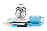 Blue coffee cup, alarm clock and office supplies