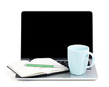 Tea cup and office supplies on laptop