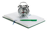 Alarm clock and pen on notepad
