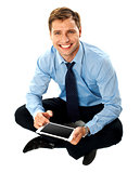 Man sitting on floor using touch screen device