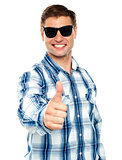 Smart young guy showing thumbs up