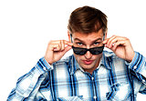 Confident young man peeping from goggles