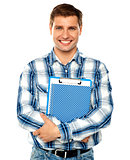 Young man holding clipboard and notepad