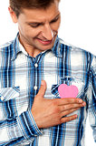 Handsome man holding paper heart