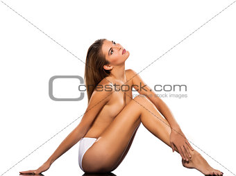 Topless beautiful woman sitting on floor full length