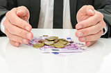 Businessman holding hands around Euro money