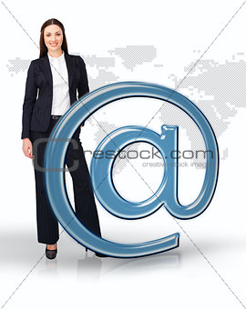 Businesswoman standing by email at symbol