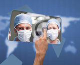Hand selecting image of surgeons on touchscreen
