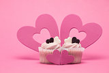 Two valentines cupcakes with four heart decorations