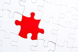 White jigsaw puzzle with one red piece
