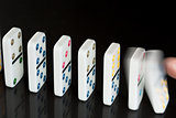 Finger pushing over colourful dominoes