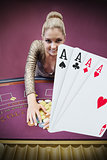 Blonde woman grabbing chips with digital hand of four aces