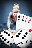Blonde woman grabbing chips with digital hand of four aces and dice