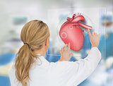 Blonde doctor consulting touchscreen displaying heart diagram