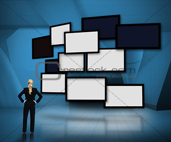 Group of blank screens on blue background with businesswoman looking up