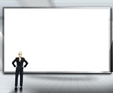 Businesswoman looking up at large blank screen