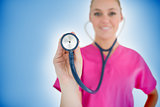 Smiling nurse holding up stethoscope