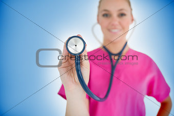 Smiling nurse holding up stethoscope