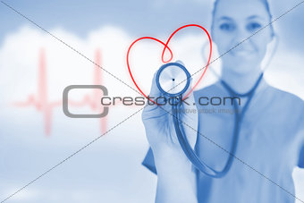 Happy nurse holding up stethoscope to heart design in blue tint