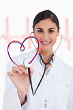 Happy doctor holding up stethoscope to heart design