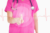 Nurse in pink scrubs touching red ECG line