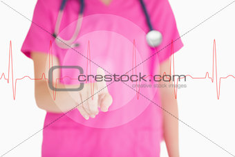Nurse in pink scrubs touching red ECG line