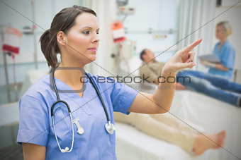 Nurse in hospital ward pointing to something