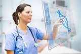 Nurse touching screen displaying blue DNA helix