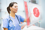 Nurse touching screen displaying red ECG line