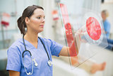 Nurse touching screen showing red ECG data