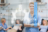 Smiling nurse standing behind blue display screen showing xray