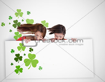 Girls looking down at blank placard with shamrocks