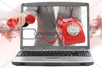 Woman reaching out from laptop handing phone receiver