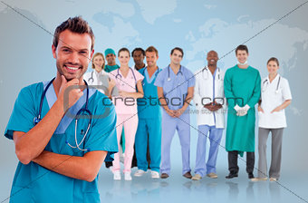 Happy doctor with medical staff behind him