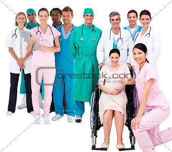 Nurse with pregnant woman in wheelchair with medical staff