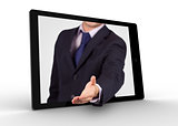 Businessman reaching out from tablet for handshake