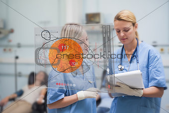 Serious nurses looking at an interface during the blood donation