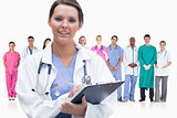 Woman doctor standing in front of her team in row