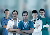 Smiling hospital workers standing arms crossed in line