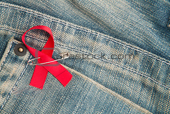 Aids awareness ribbon pinned on to jeans