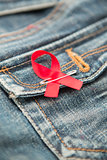 Aids awareness ribbon pinned on to jeans pocket