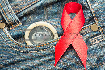 Condom peeking out from pocket with red awareness ribbon