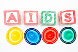 Wood blocks spelling out aids with four colourful condoms