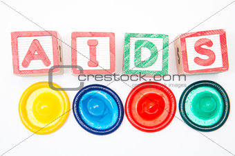 Wood blocks spelling out aids with four colourful condoms